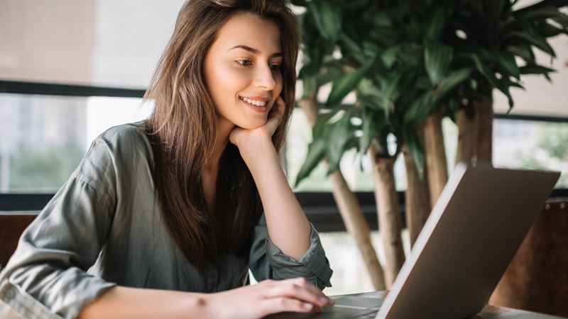 Lady smiling while looking at laptop
