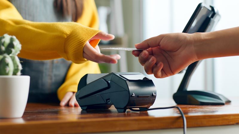 Lady handing card to cashier